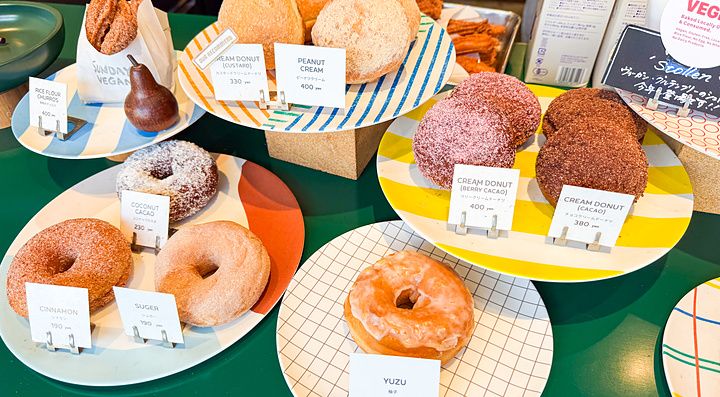 Donut vegani esposti su piatti colorati nel negozio Sunday Vegan a Kichijoji.