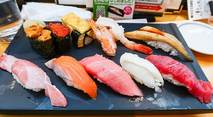 Assortimento di sushi su un vassoio nero al ristorante Sushi Zanmai.