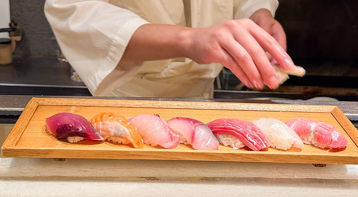 Un vassoio di legno con nigiri sushi freschi poggiato su un bancone presso il ristorante Sushimaru a Shinjuku.