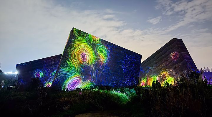 Installazione di luci colorate con vortici su strutture architettoniche nel teamLab Botanical Garden Osaka.