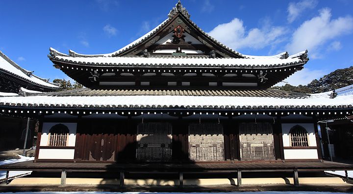 Facciata del tempio Sennyu-ji a Kyoto coperta di neve sotto un cielo azzurro.