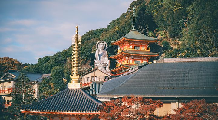 Veduta del tempio Shigisan Chogosonshi-ji con una statua del Buddha e pagode tra alberi autunnali a Nara, Giappone.