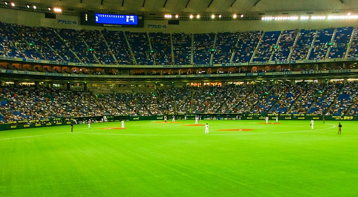 Veduta panoramica interna del Tokyo Dome durante una partita di baseball con spettatori sugli spalti.