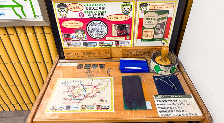 Postazione per timbri commemorativi con mappa e inchiostro situata all'interno della stazione Azabu-juban a Tokyo.