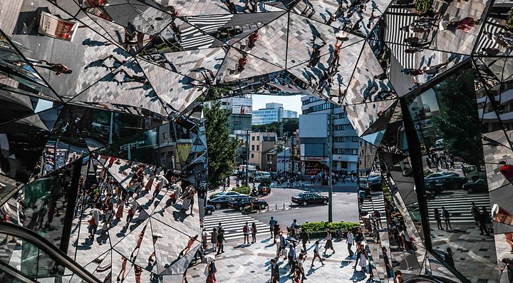 Veduta caleidoscopica attraverso gli specchi dell'ingresso del Tokyu Plaza ad Harajuku, con persone che camminano in strada.