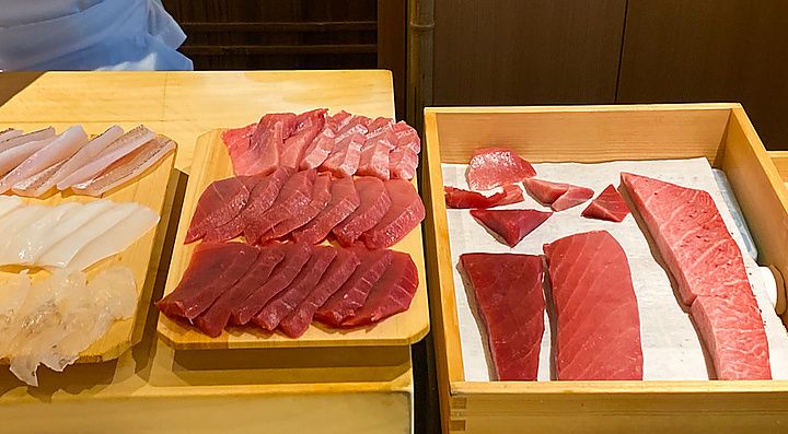 Tagli di tonno disposti su taglieri e in una cassetta di legno presso il ristorante da Sushi Masashi a Tokyo.