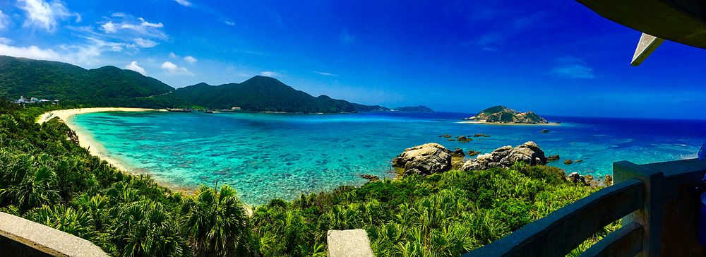 Vista panoramica della spiaggia Aharen a Tokashiki, Okinawa, con mare blu e sabbia bianca.