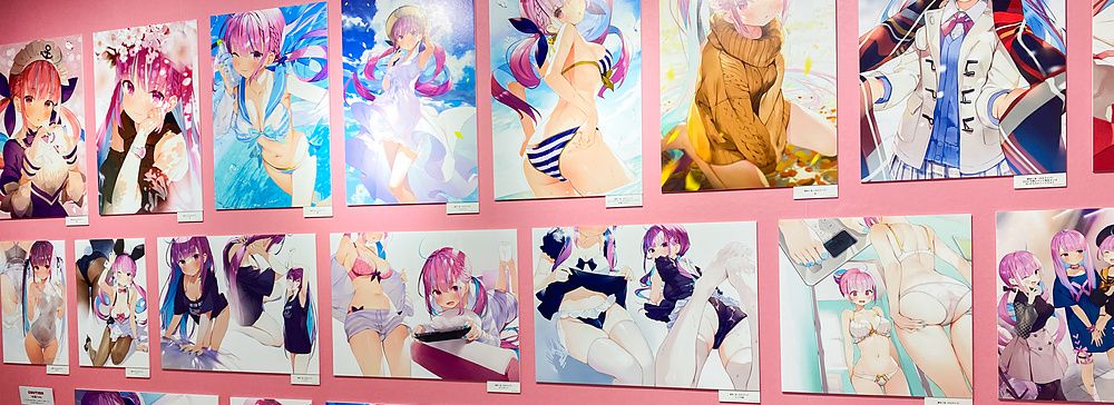 Illustrazioni di arte manga esposte su una parete rosa in una mostra.