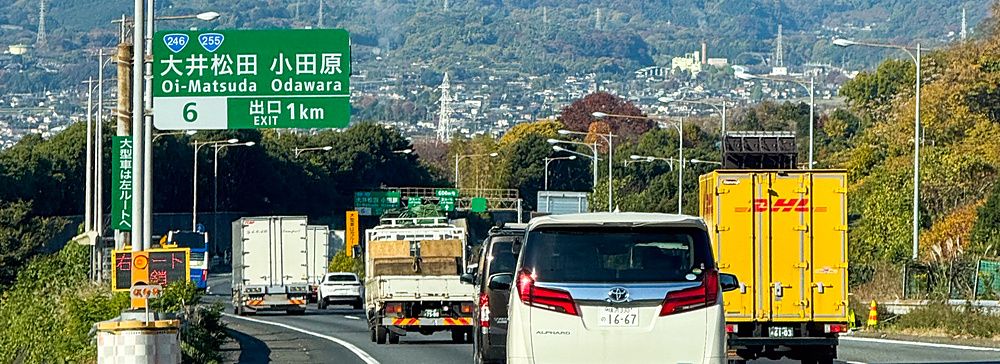 Auto lungo un'autostrada giapponese con il Monte Fuji sullo sfondo.