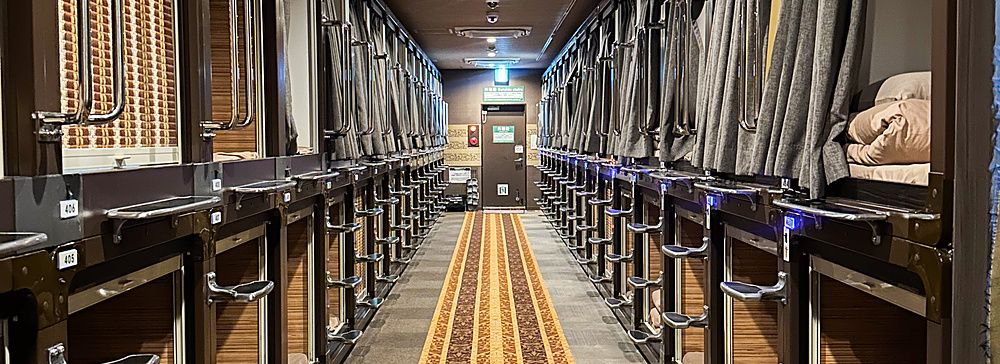 Corridoio di un capsule hotel con capsule su entrambi i lati.