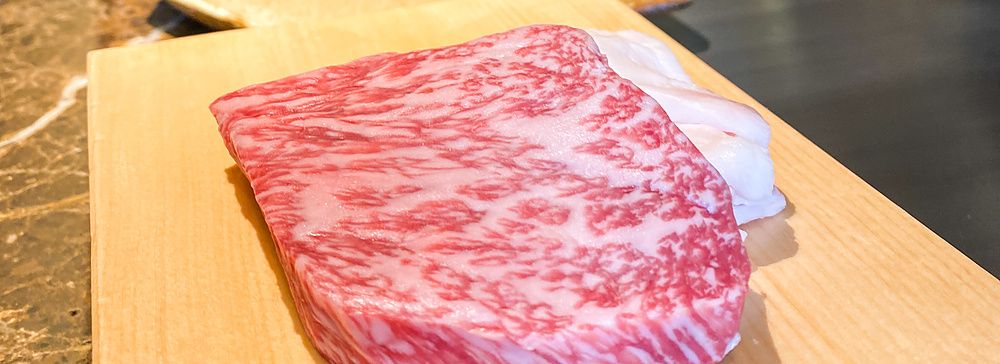 Una fetta di manzo di Kobe su un tagliere di legno all'interno del ristorante Kobe Beef Ishida a Ginza, Tokyo.