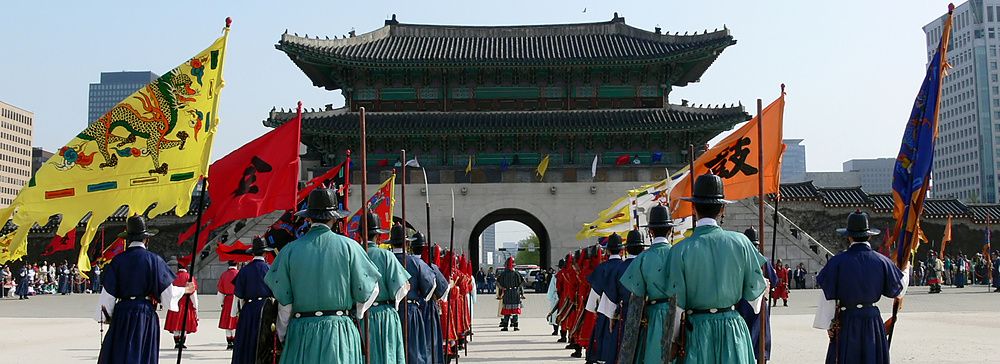 Cerimonia delle guardie reali al Gyeongbokgung Palace a Seoul con bandiere colorate.