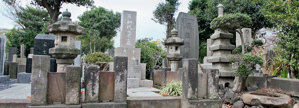 Cimitero giapponese a Yanaka, Tokyo, con lapidi e lanterne in pietra.