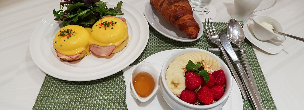 Una colazione con uova alla Benedict e una ciotola di frutta e cereali su un tavolo del ristorante Sarabeth a Tokyo.