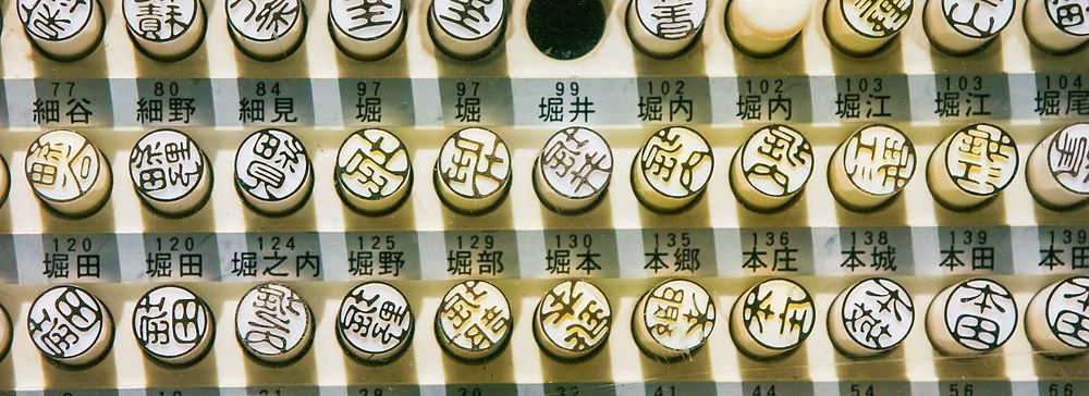 Timbri giapponesi hanko esposti su una griglia, con diversi ideogrammi.