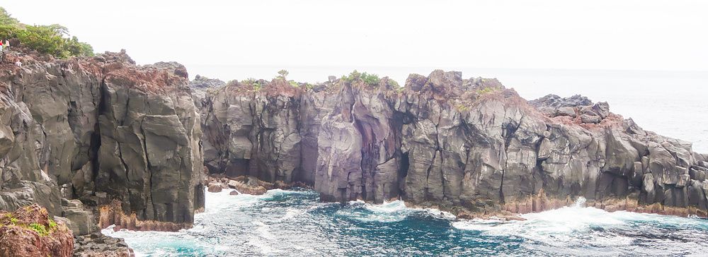 Scogliere di roccia vulcanica scura si affacciano sull'oceano presso la Costa di Jogasaki (Giappone).