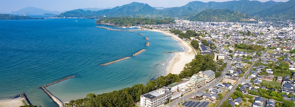 Ripresa aerea di Hagi con la spiaggia di Kikugahama, il mare azzurro, frangiflutti e il distretto di Hamasaki.