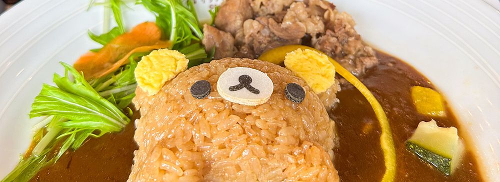 Un piatto di curry con riso a forma di orso alla Rilakkuma Tea House ad Arashiyama, con tre pupazzi sullo sfondo.