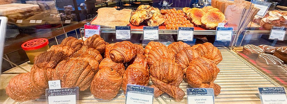 Vetrina colma di vari tipi di croissant e prodotti da forno all'interno di The City Bakery a Shibuya.