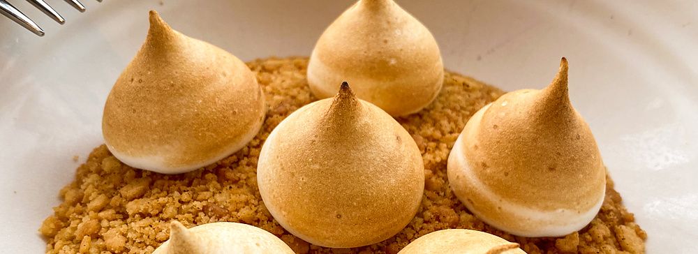 Dolce con meringhe dorate su base di granella in una ciotola bianca presso il ristorante THE APOLLO a Ginza.