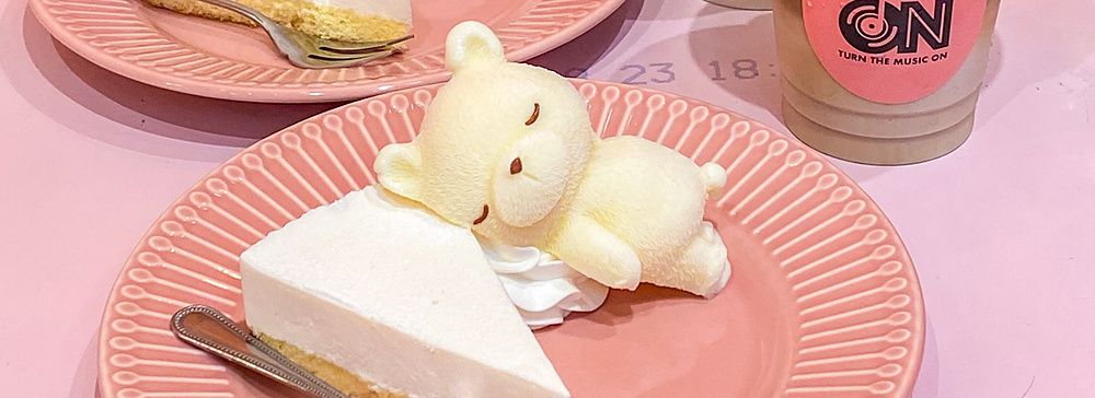 Due piatti con cheesecake e orsetti di panna accanto a caffè ghiacciati con orsetti di ghiaccio al Cafe ON di Tokyo.
