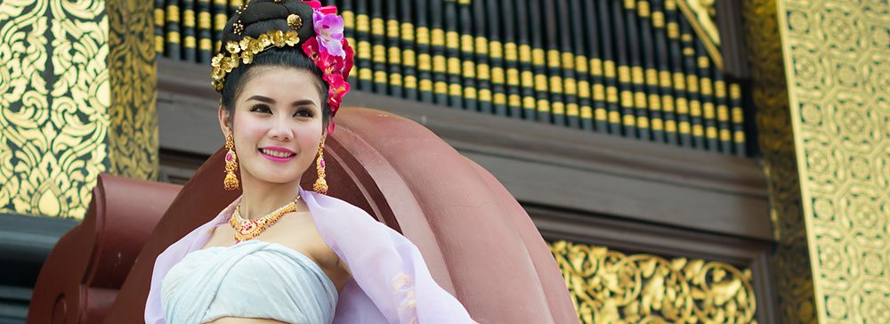 Donna thailandese in abito tradizionale con sfondo dorato.