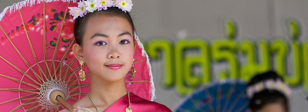Donna in costume tradizionale con ombrello al Festival degli Ombrelli a Chiang Mai.