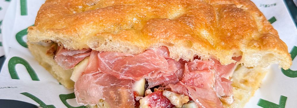 Una focaccia con crudo, gorgonzola, fichi e noci servita su carta marchiata Tutu presso un ristorante a Meguro, Tokyo.