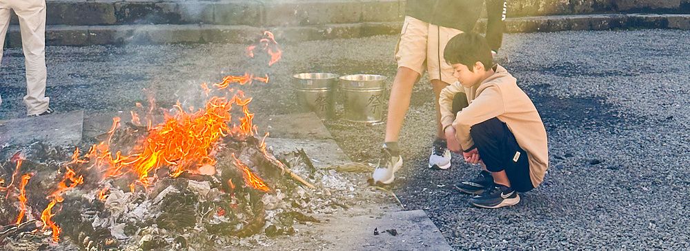Persone attorno a un fuoco durante l'hatsumode al Santuario Kitaguchihongu Fuji Sengenjinja.