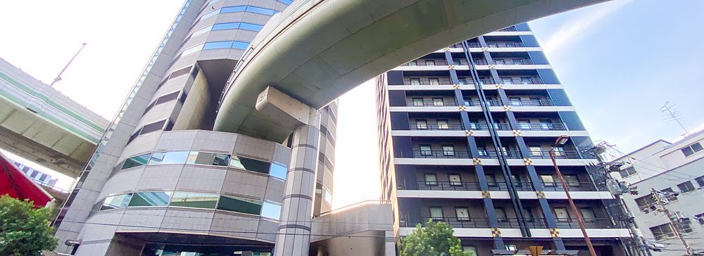 Veduta dal basso del Gate Tower Building a Osaka, con un'autostrada che attraversa la struttura dell'edificio.
