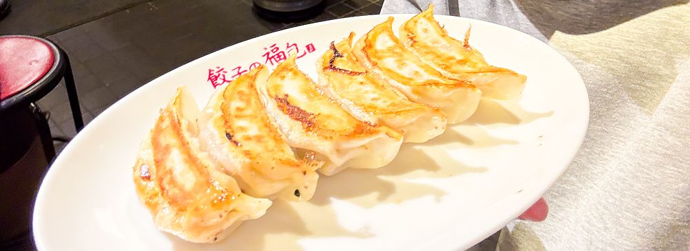 Marco Togni tiene un piatto di gyoza alla piastra a Gyoza no Fukuho in un ristorante di Tokyo.