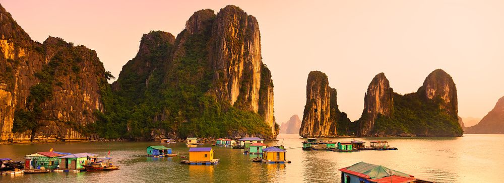 Halong Bay in Vietnam con case galleggianti e formazioni calcaree imponenti.