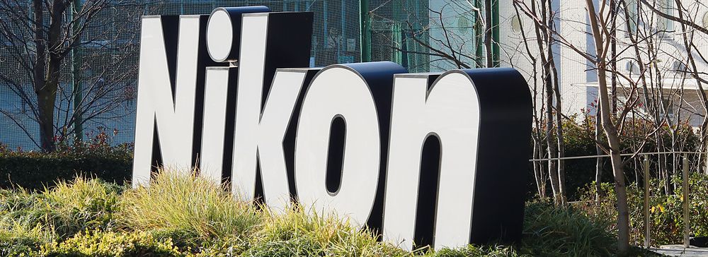 Insegna tridimensionale con il logo Nikon posizionata in un'aiuola all'esterno della sede aziendale a Tokyo.