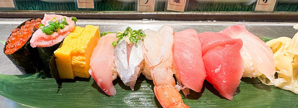 Assortimento di sushi variopinto su una foglia verde in un ristorante.