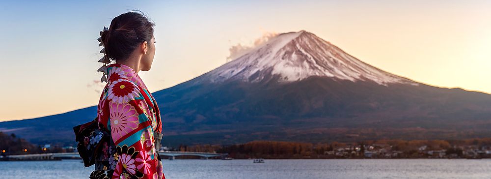 Donna in kimono di fronte al Monte Fuji al tramonto sul lago Kawaguchiko.
