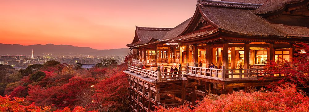 Tempio Kiyomizu-dera di Kyoto al tramonto con foglie autunnali rosse.