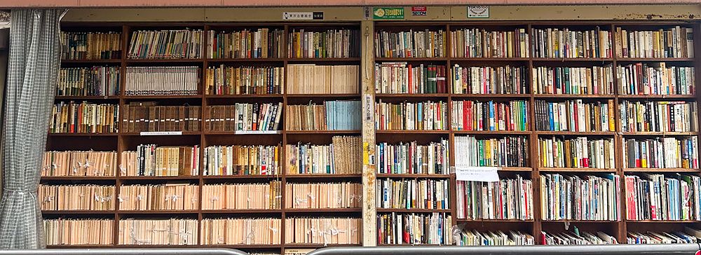 Facciata di una libreria a Jimbocho con scaffali di libri e insegna giapponese.