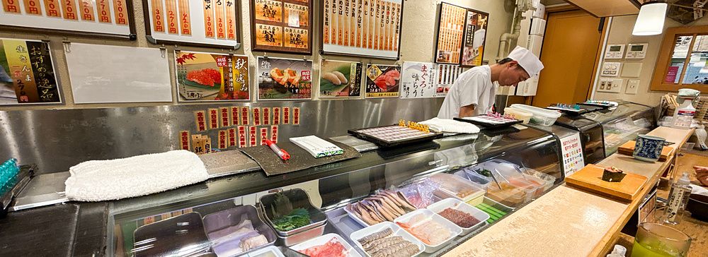 Chef al lavoro dietro il bancone del ristorante Maguro Bito.
