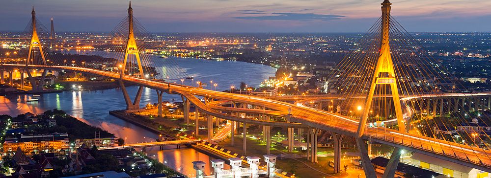 Il Mega Bridge di Bangkok illuminato di notte sopra il fiume.