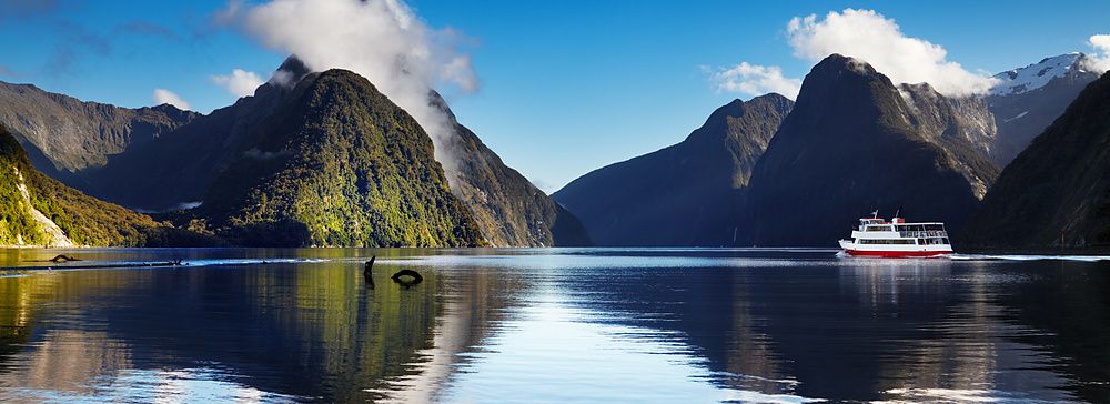Panorama di Milford Sound con una nave da crociera su acque calme.