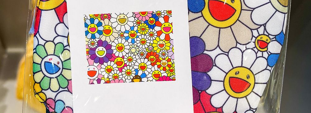 Mascherina con fiori colorati di Takashi Murakami confezionata con cartellino MoMA nel MoMA Design Store a Tokyo.