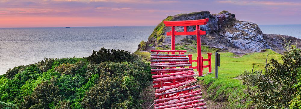 Torii rossi al Motonosumi Inari Shrine in Giappone con vista sull'oceano.