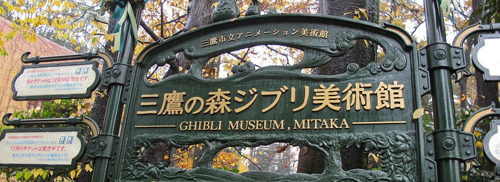 Insegna del Museo Ghibli a Mitaka tra gli alberi autunnali.