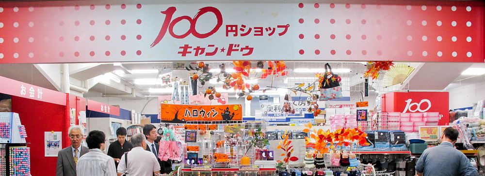 Negozio tutto a 100 yen in Giappone con persone e scaffali pieni di articoli.