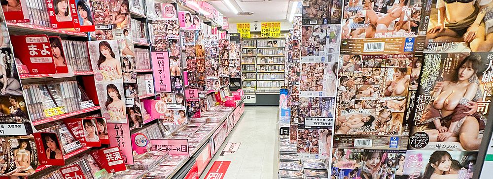 Corridoio di un negozio per adulti in Giappone con DVD e riviste sugli scaffali.