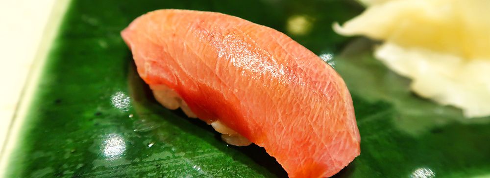 Un nigiri di chutoro servito su un piatto di ceramica verde presso il ristorante Ginza Kyubey di Tokyo.