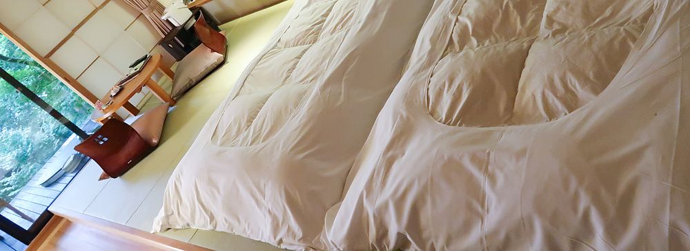 Stanza dell'Oku Nikko Hotel Shikisai con futon tradizionali e tavolino basso.