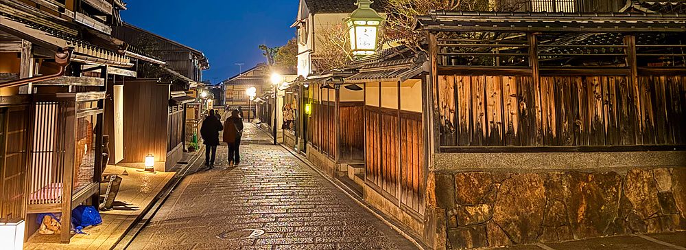 La pagoda Yasaka a Kyoto svetta illuminata durante una notte limpida sopra la strada acciottolata del quartiere storico.