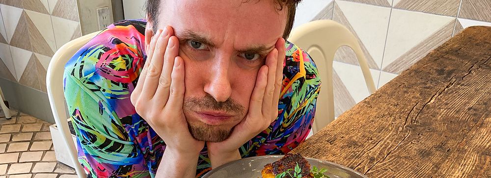 Marco Togni a un tavolo con pancake alla pesca a Flipper's e bevanda chiara.