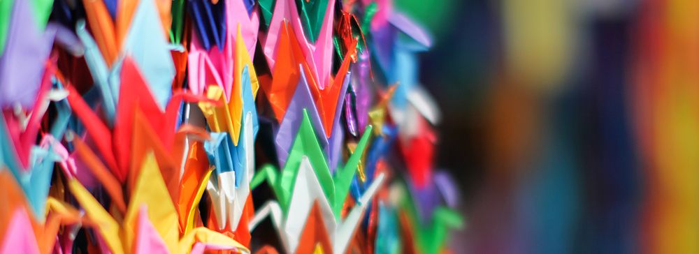 Molteplici gru di carta piegata di diversi colori sono appese in file verticali all'interno del Memoriale di Hiroshima.
